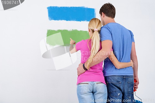 Image of happy couple paint wall at new home