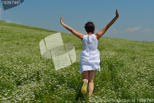 Image of Young happy woman in green field