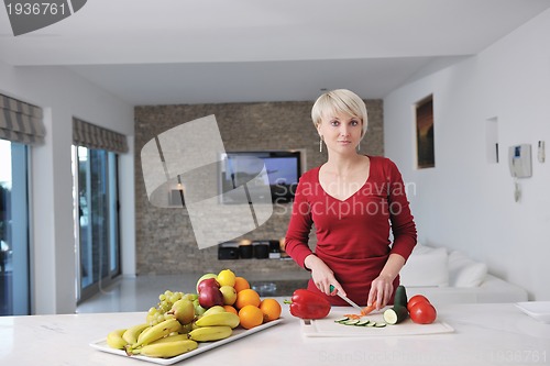 Image of happy  beautiful blonde  woman prepare food in  the kitchen
