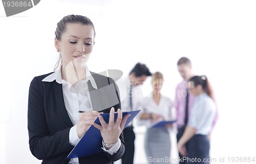 Image of business woman standing with her staff in background