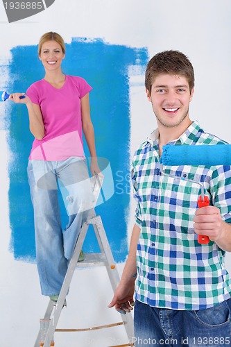 Image of happy couple paint wall at new home