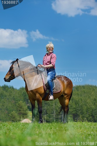 Image of happy woman  on  horse