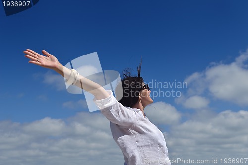 Image of happy young woman with spreading arms to sky