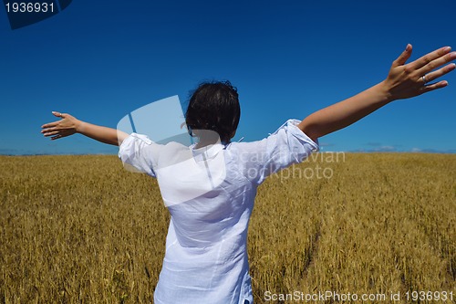 Image of young woman in wheat field at summer