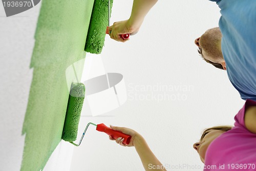 Image of happy couple paint wall at new home