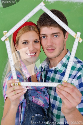 Image of happy couple paint wall at new home