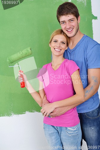 Image of happy couple paint wall at new home