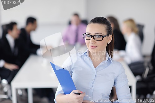 Image of business woman standing with her staff in background