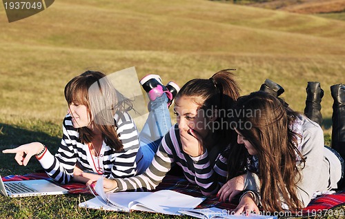 Image of group of teens working on laptop outdoor