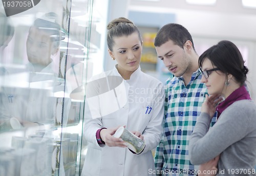 Image of pharmacist suggesting medical drug to buyer in pharmacy drugstor