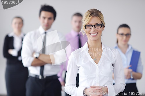 Image of business woman standing with her staff in background