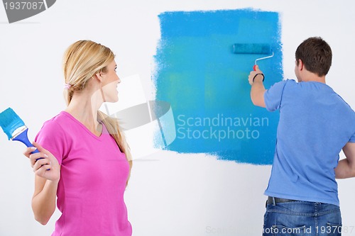 Image of happy couple paint wall at new home