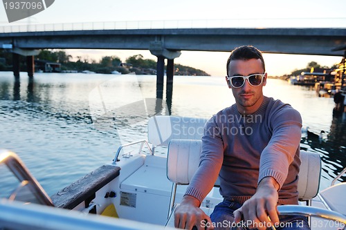 Image of portrait of happy young man on boat