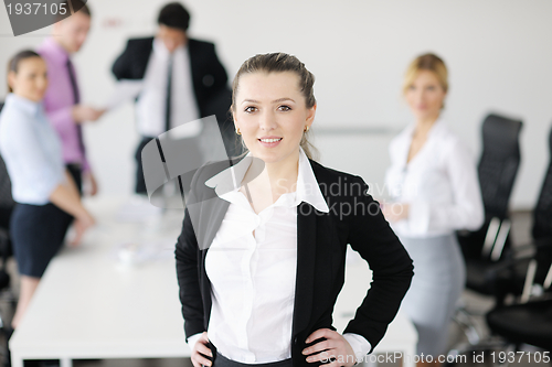 Image of business woman standing with her staff in background