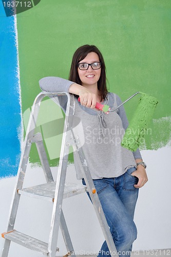 Image of happy smiling woman painting interior of house