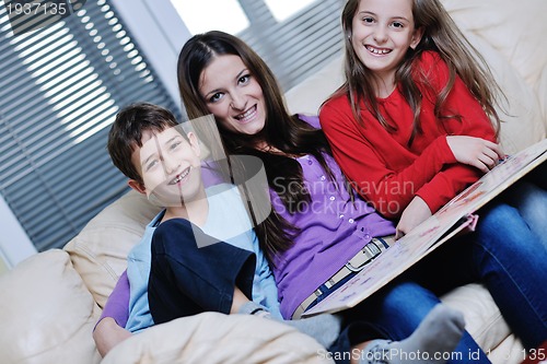 Image of young mom play with their kids at home and reading book