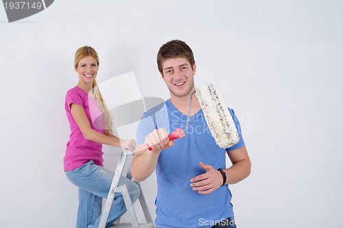 Image of happy couple paint wall at new home