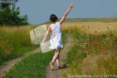 Image of young woman in wheat field at summer