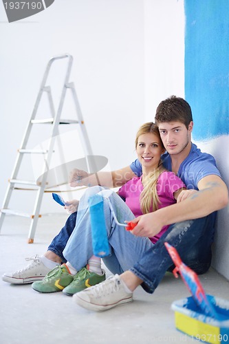 Image of happy young cople relaxing after painting in new home