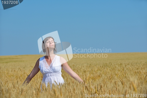 Image of young woman in wheat field at summer
