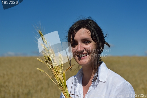 Image of young woman in wheat field at summer