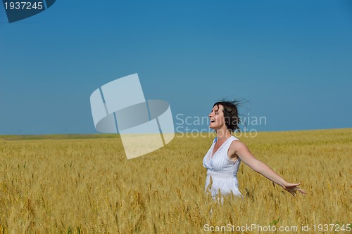 Image of young woman in wheat field at summer