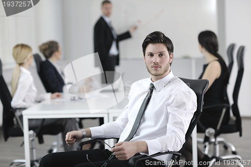 Image of handsome young business man with colleagues in background