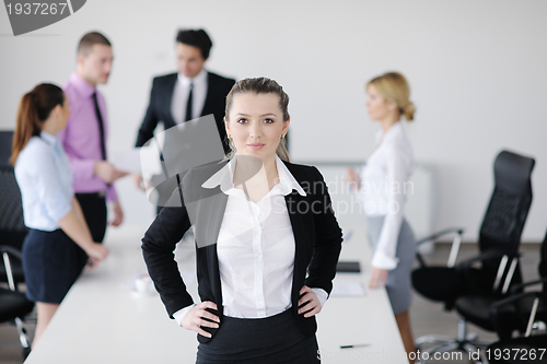 Image of business woman standing with her staff in background