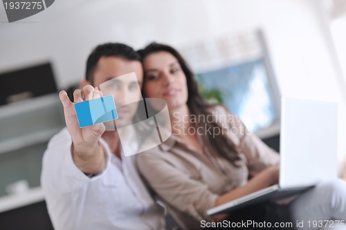 Image of joyful couple relax and work on laptop computer at modern home