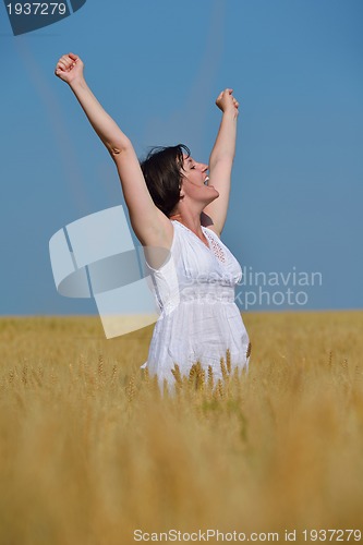 Image of young woman in wheat field at summer