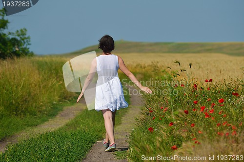 Image of young woman in wheat field at summer