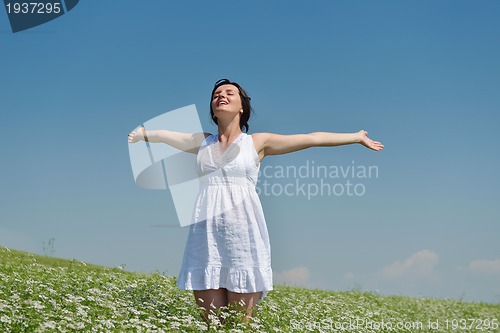 Image of Young happy woman in green field