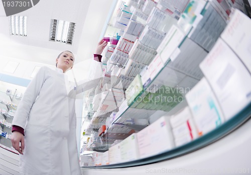 Image of pharmacist chemist woman standing in pharmacy drugstore