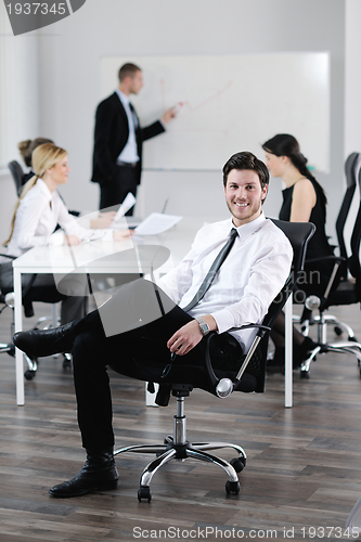 Image of Portrait of a handsome young business man with colleagues in bac