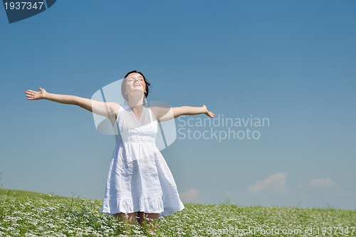Image of Young happy woman in green field