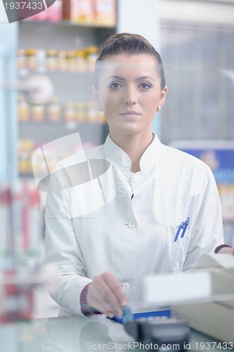 Image of pharmacist chemist woman standing in pharmacy drugstore
