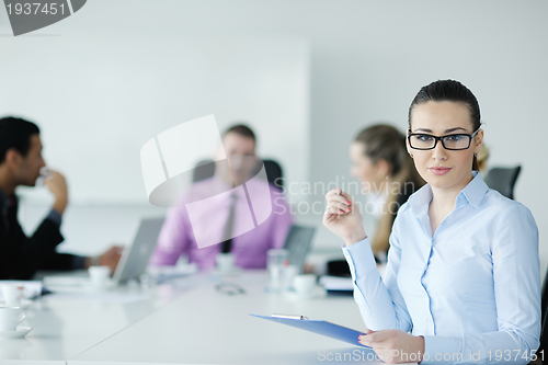 Image of business woman standing with her staff in background