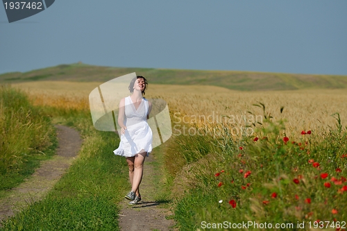 Image of young woman in wheat field at summer