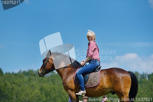 Image of happy woman  ride  horse