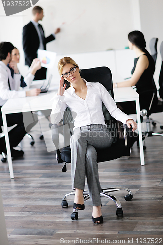 Image of business woman with her staff in background
