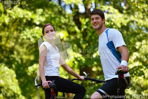 Image of Happy couple ridine bicycle outdoors