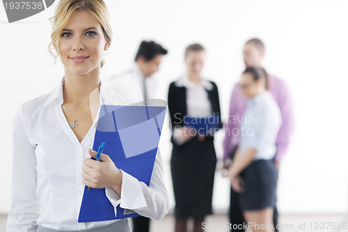 Image of business woman standing with her staff in background