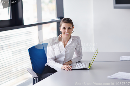 Image of Young pretty business woman with notebook in the office