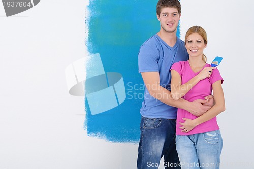 Image of happy couple paint wall at new home