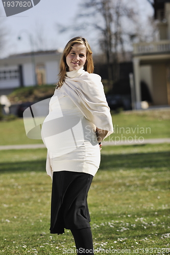 Image of happy young pregnant woman outdoor