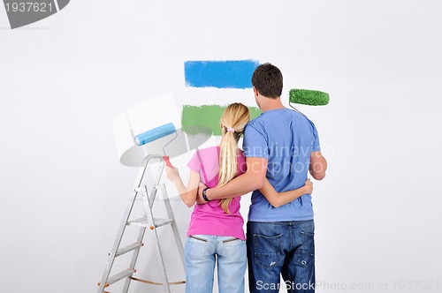 Image of happy couple paint wall at new home