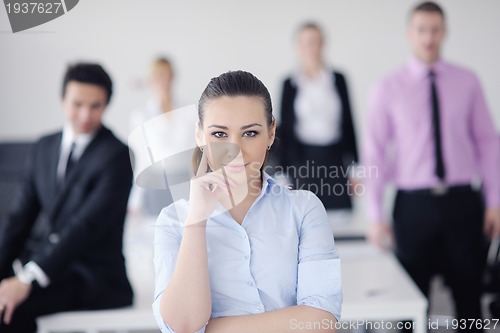 Image of business woman standing with her staff in background