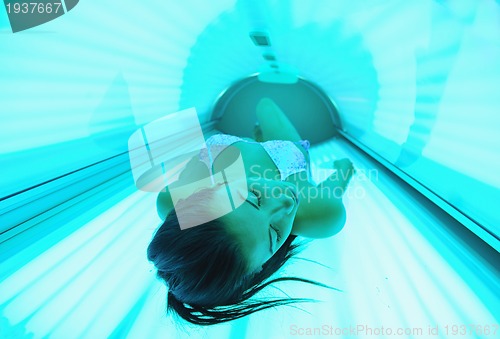 Image of Beautiful young woman tanning in solarium