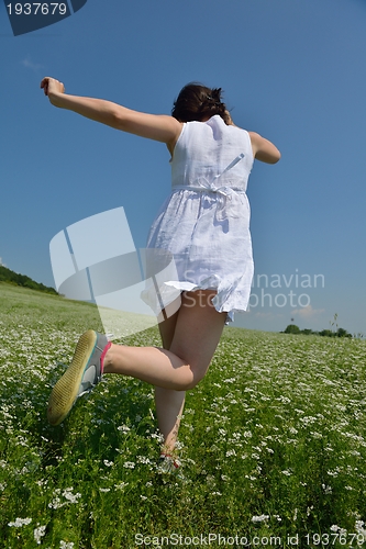 Image of Young happy woman in green field