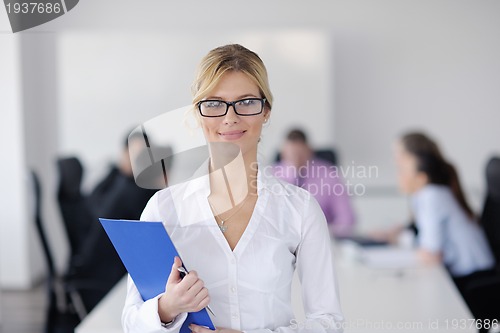 Image of business woman standing with her staff in background